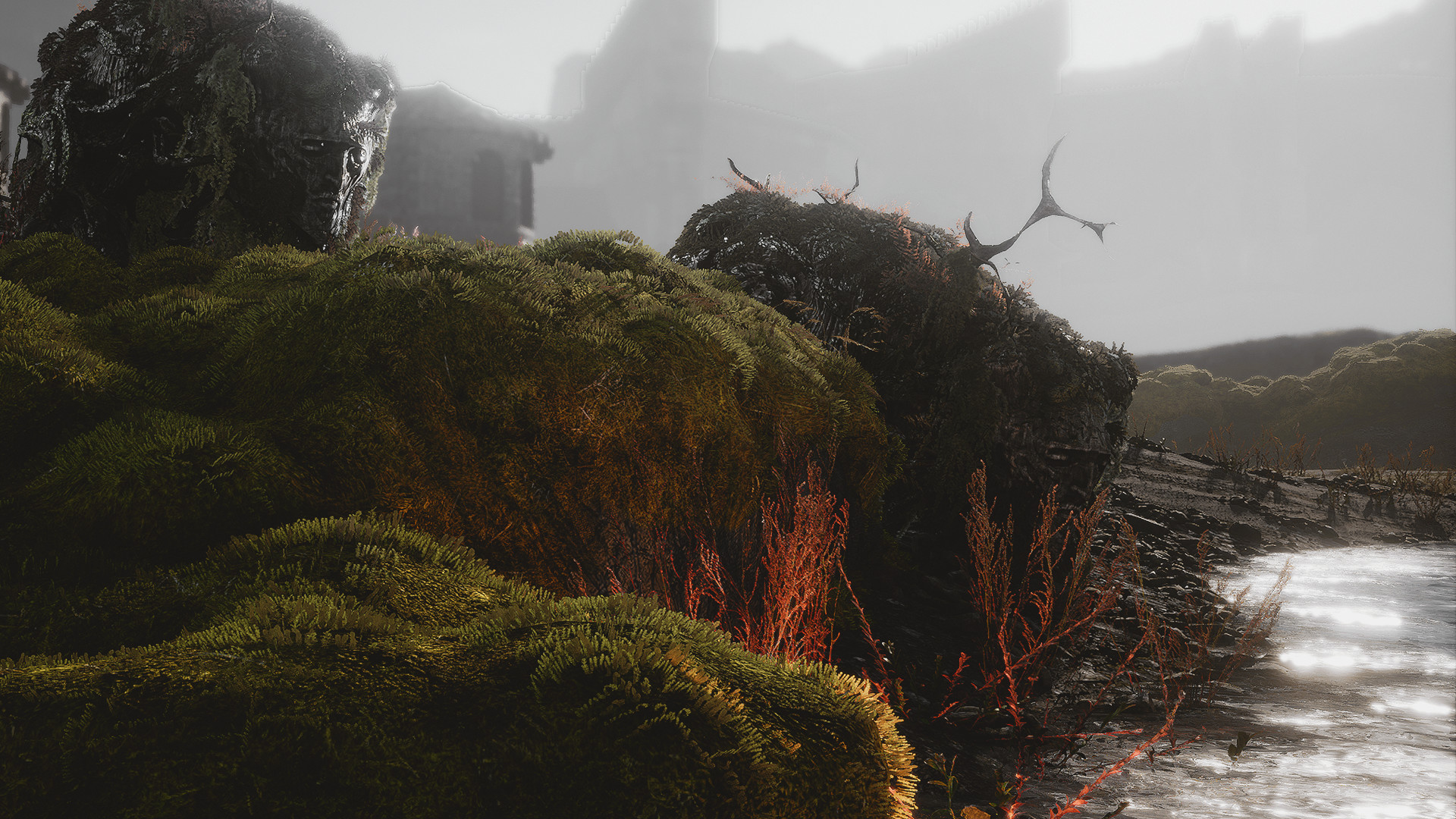 Atop a hill of moss, there is a massive stone head looking out over a small pond. The background is foggy and blurred, but large rock structures can be seen in the distance.