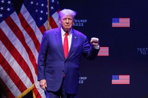 Former US President Donald Trump raises his fist as he arrives on stage to speak about education policy at the Adler Theatre in Davenport, Iowa on March 13, 2023