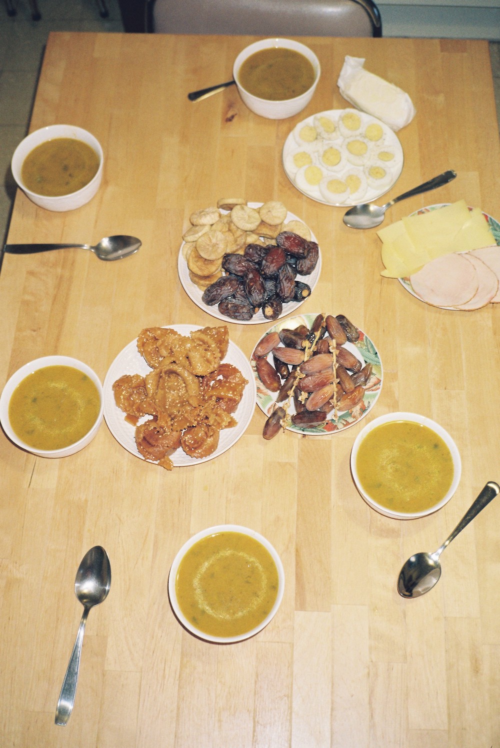 Ramadan photos. a tale with five bowls of soup, oriental cakes dates, cheese and chicken.