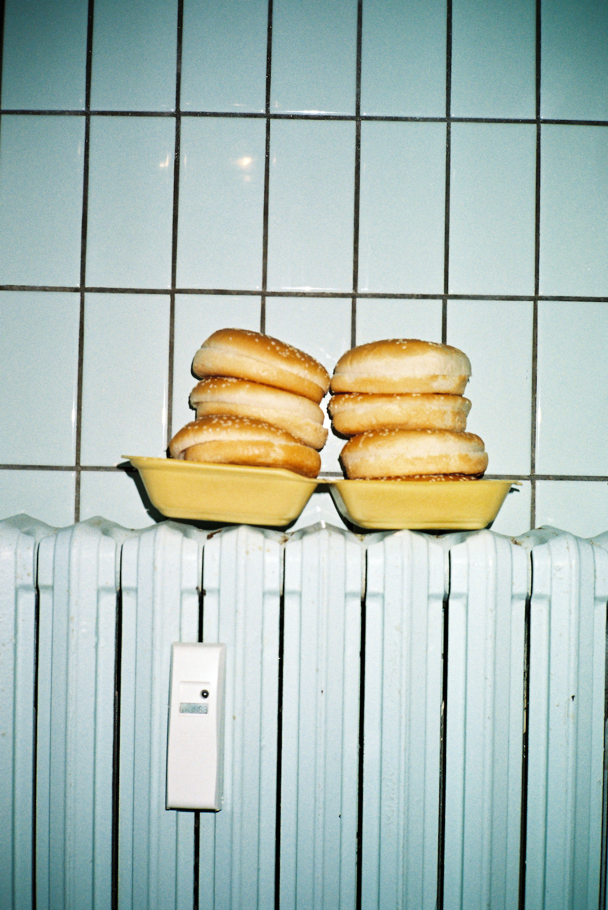 Ramadan photos. Two piles of burgers in a yellow box on a heater.