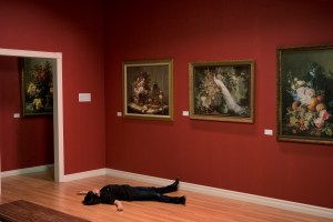 Woman lying unconscious on art gallery floor