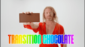 JP Sears wears a red dress and holds out a bar of chocolate in a transphobic mock ad.