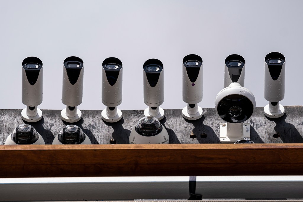 Image shows a row of security cameras from below.