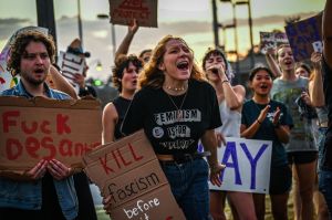 A group of young LGBTQ activists hold signs protesting Florida's Don't Say Gay law