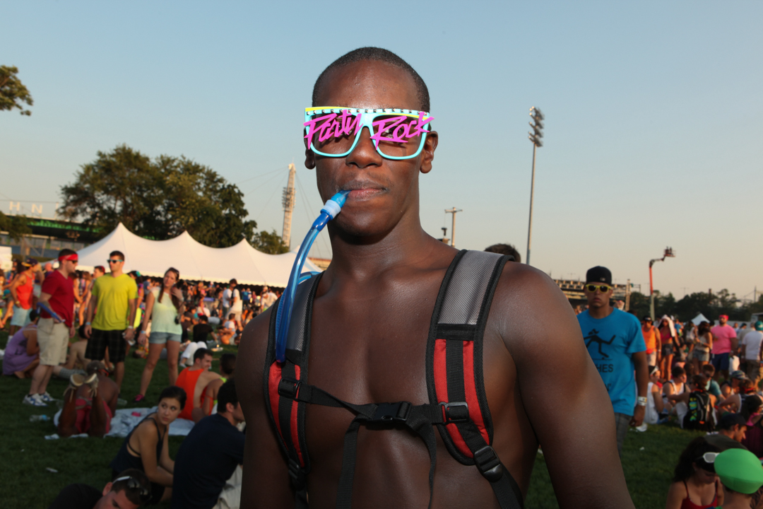 A topless man in 80s shades on Randall's Island, New York.