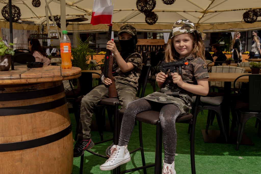 Two young people in Rzeszów​ prepare to celebrate Poland's constitution day.