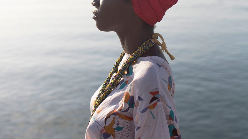 black woman standing in front of a body of water