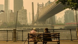 People sit on a bench during bad air quality as smoke of Canadian wildfires brought in by wind in New York, United States on June 7, 2023.