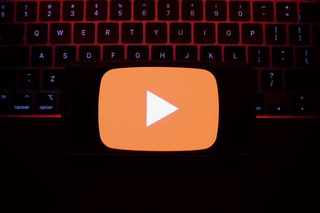 youtube logo in front of dark red computer