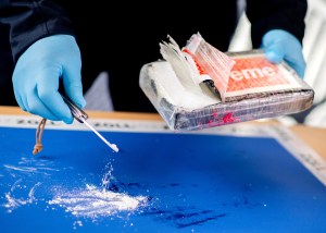 A customs officer opens a package of cocaine discovered by customs in a container