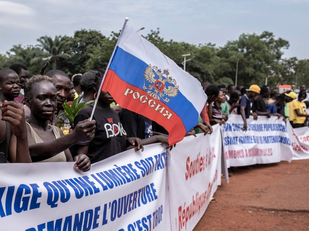 A demonstrator holds a Russian flag with the emblem of Russia on in Bangui, on March 22, 2023 during a march in support of Russia and China's presence in the Central African Republic.