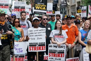 Members of the Writers Guild of America and the Screen Actors Guild pose for a photo while walking a picket line