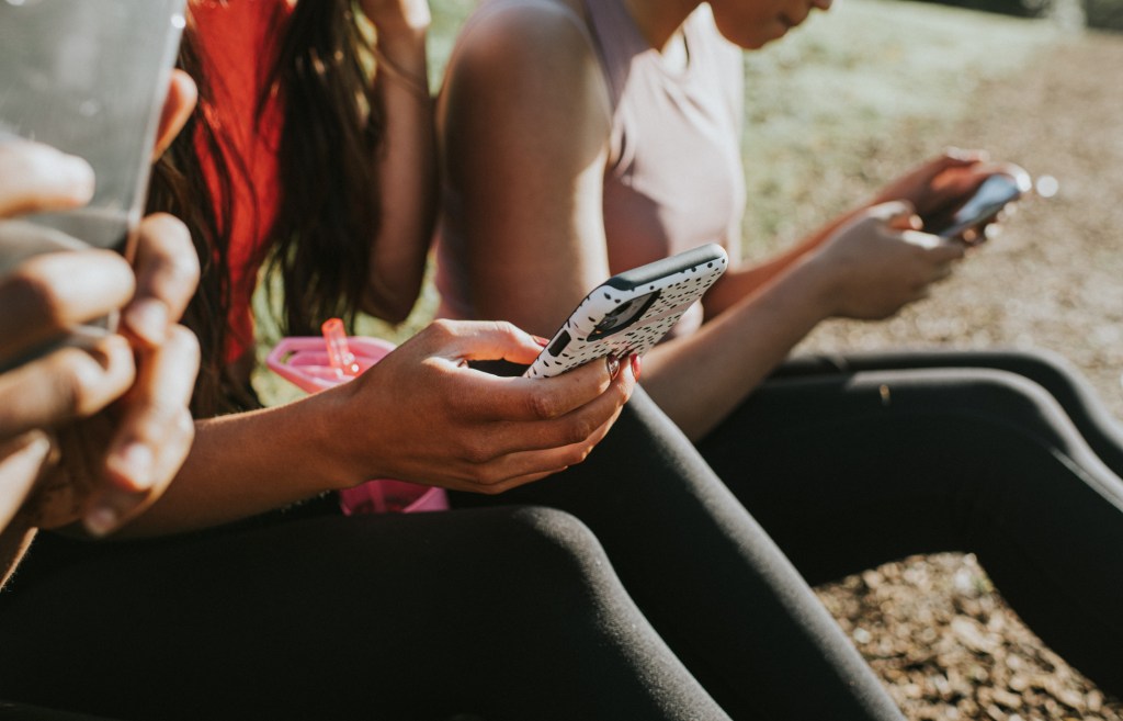 Drie vrouwen die op hun telefoon bezig zijn