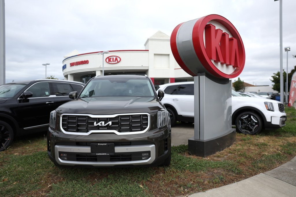 Kia car next to Kia sign