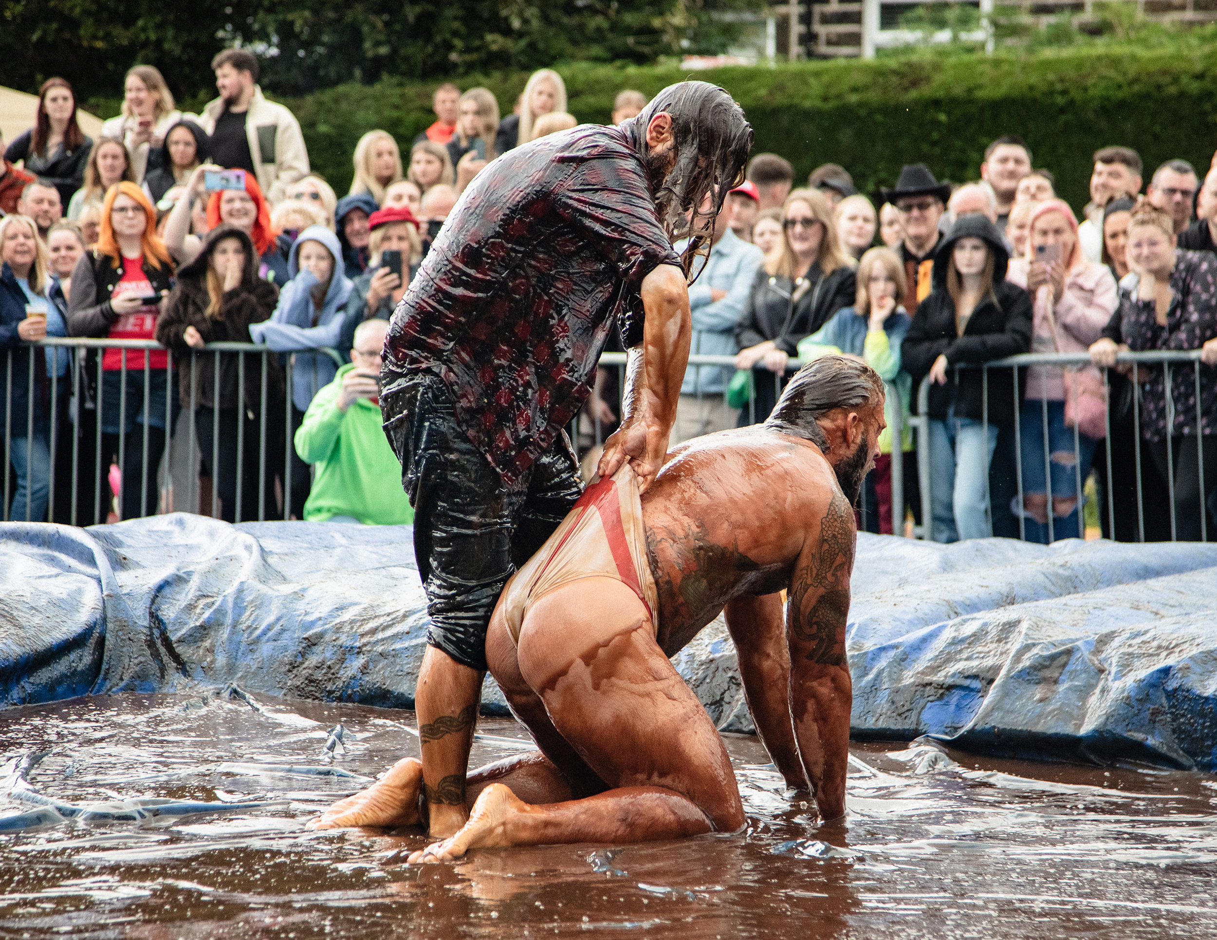 world gravy championships - a photo of two men wrestling in a gravy filled wrestling ring.