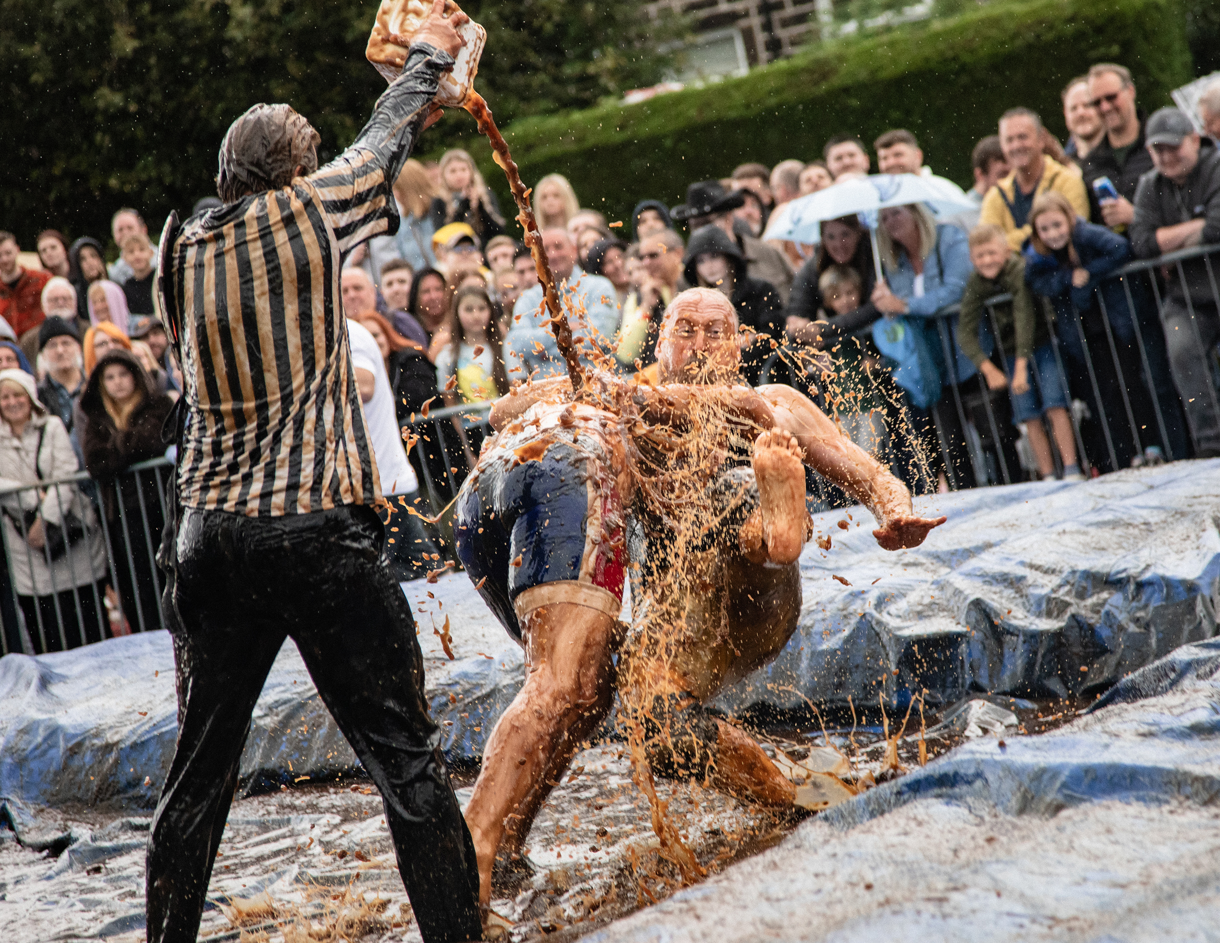 world gravy championships - a photo of two men wrestling in a gravy filled wrestling ring.