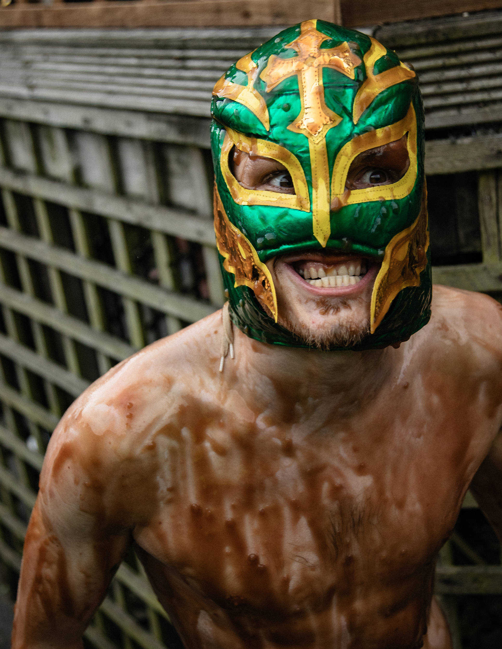 world gravy championships - a portrait of a man topless covered in gravy wearing a mexican wrestling mask.