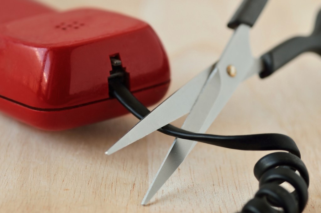 Scissors cutting a phone cable