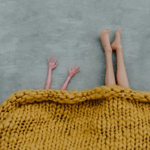 The Mistakes You Could Have Avoided if Y Had Received Proper Sex Ed photo of two barbies under a yellow mustard blanket, only their feet and hands are visible