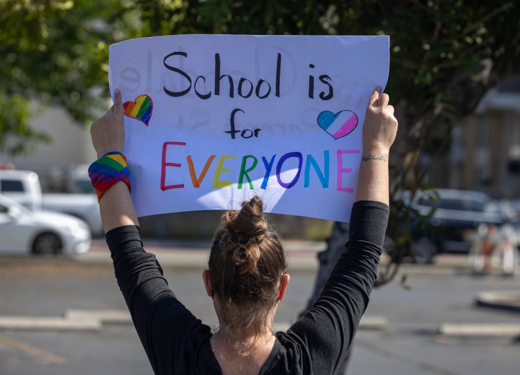 A pro-LGBTQ+ demonstrator holds a sign outside a Glendale Unified School District (GUSD) Board of Education meeting on June 20, 2023 in Glendale, California.