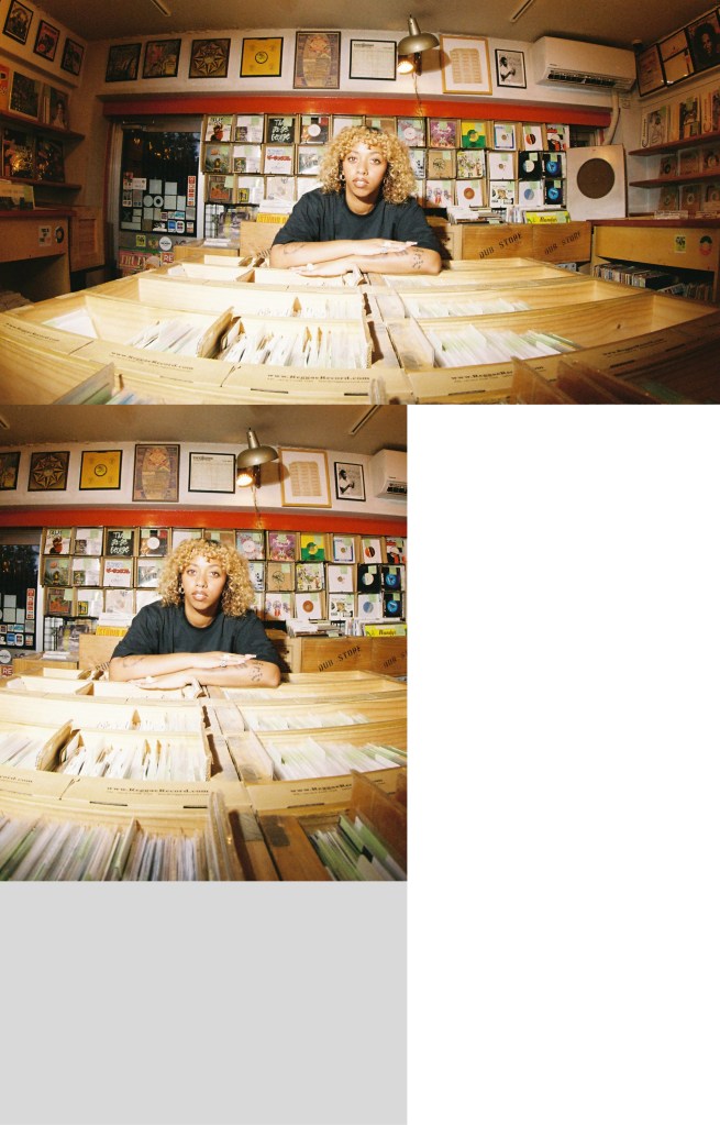 Nia Archives poses for a photo behind the counter in the record store.