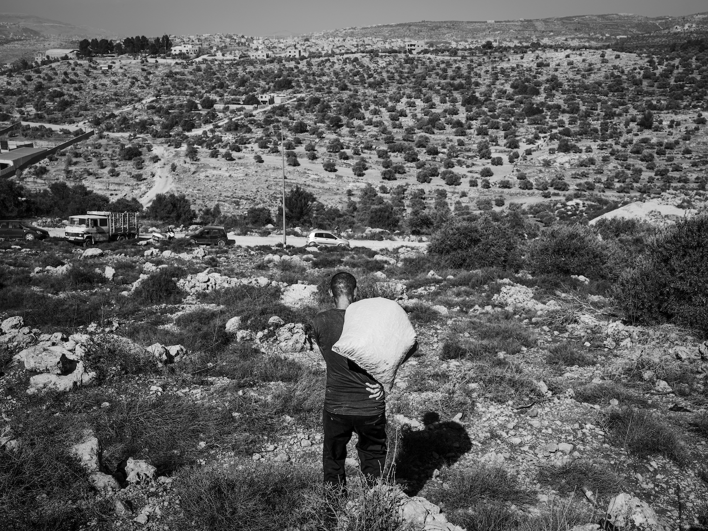 A man carrying a heavy bag on his shoulder