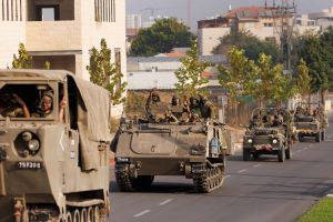 Israeli soldiers give peace and thumbs-up gestures as Israeli tanks and troops move near the border with Gaza on October 28, 2023 in Sderot, Israel.