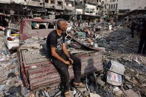 A man sits amid the destruction following Israeli strikes on Al-Shatee camp in Gaza City on October 28, 2023.