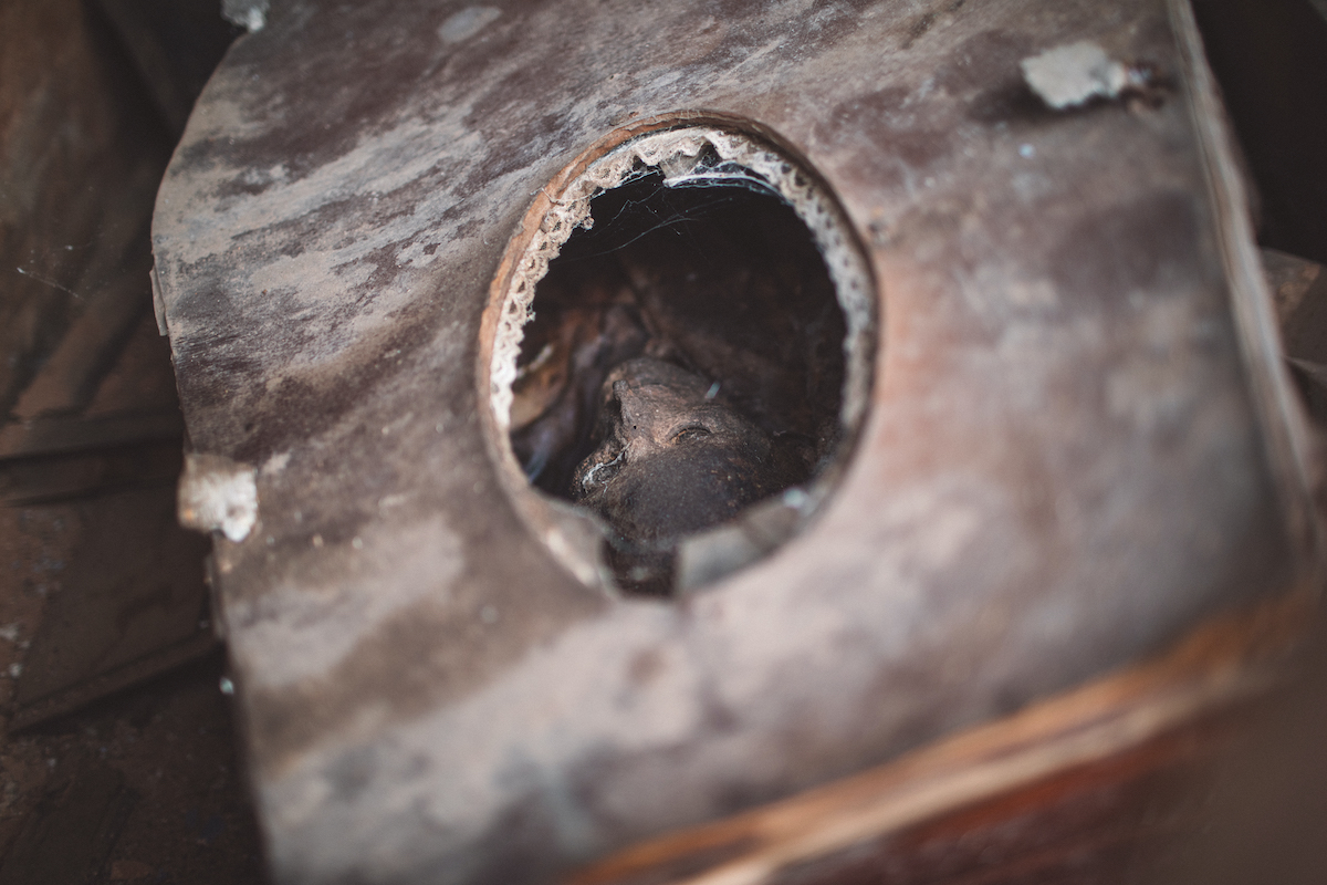 A photo of a wooden casket with a hole cut into it through which you can see a skeleton covered in dirt.