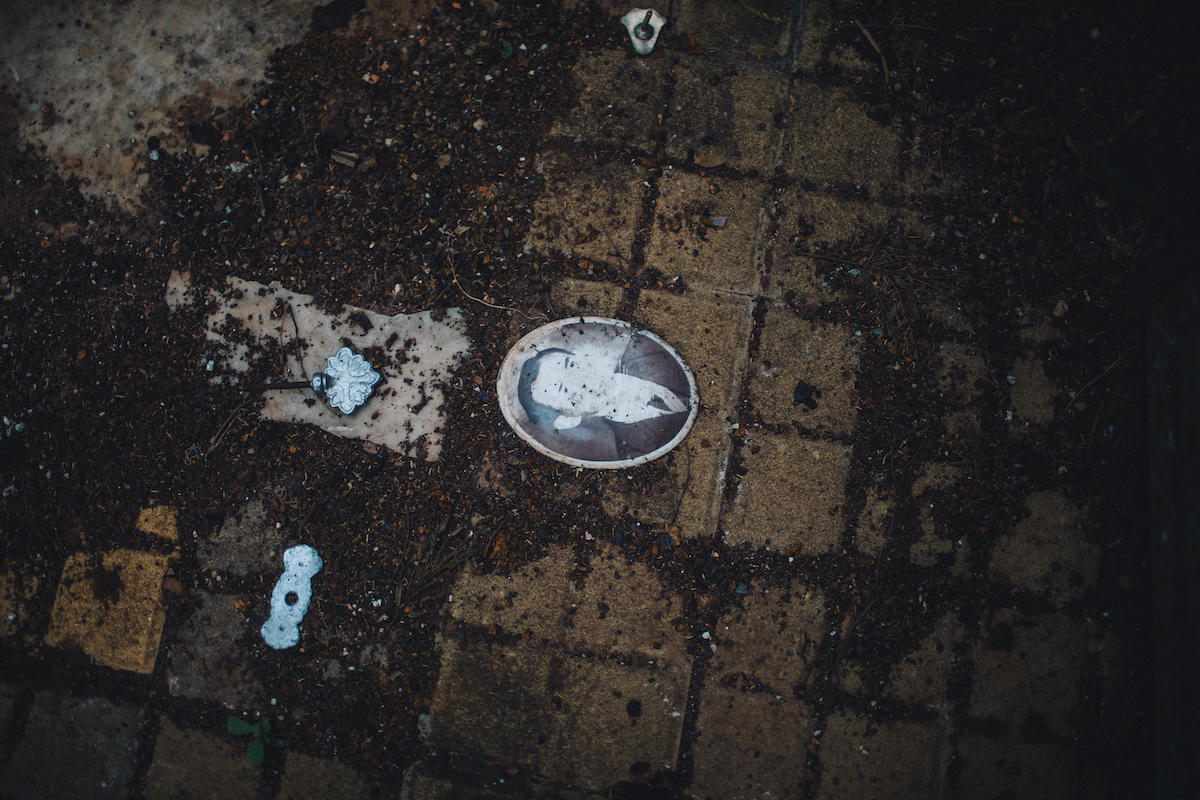 A photo of a black and white picture of man, discarded on the ground and covered in dirt