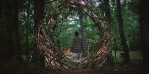 ​A woman next to a nature installation built by participants on the retreat in Spain