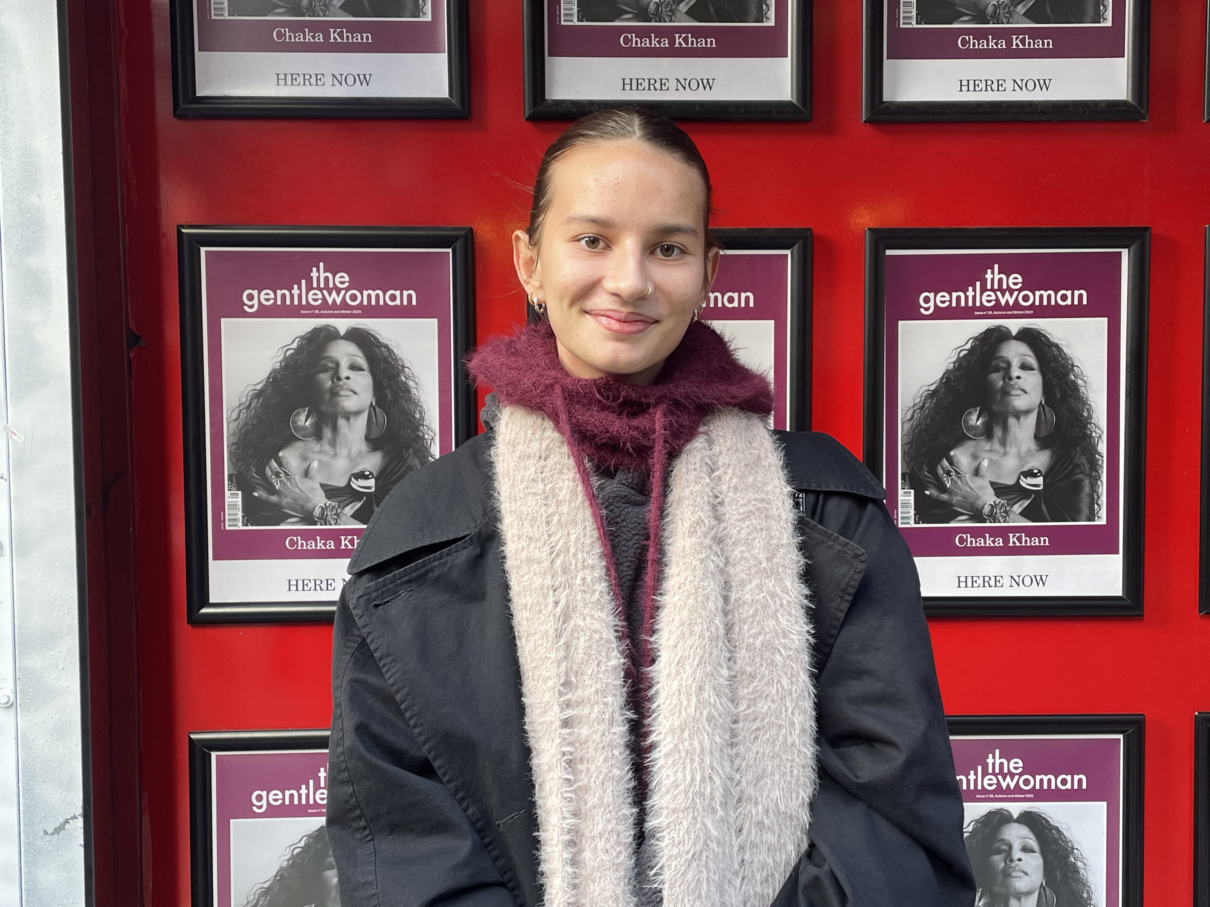 Girl in dark mac with a fluffy cream scarf and maroon hoodie