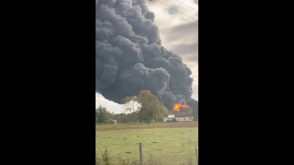 Thick black smoke billowing from a large fire