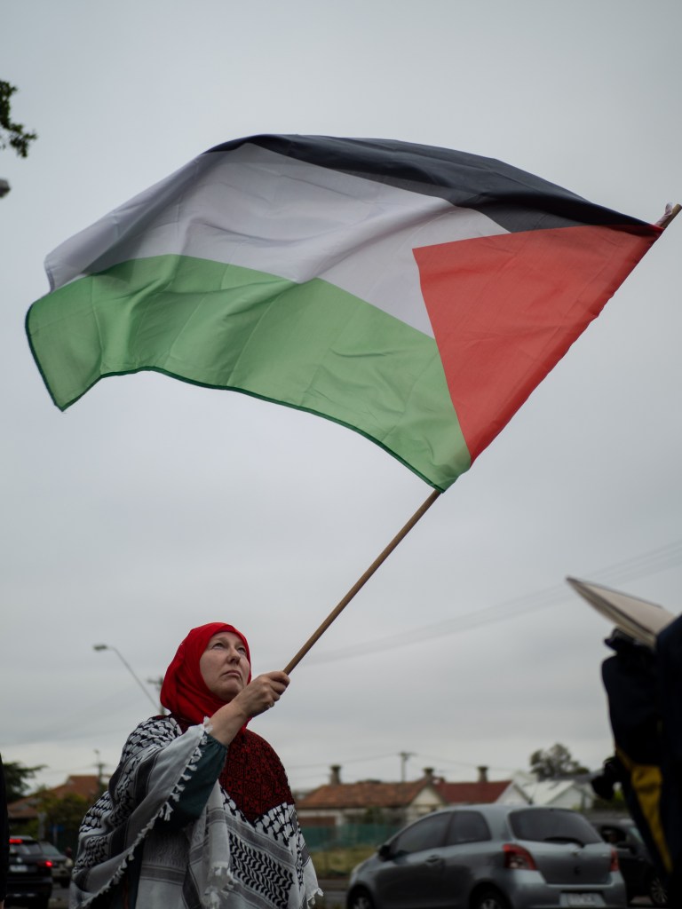 A protester waves a Palestinian flag during a rally in Coburg,