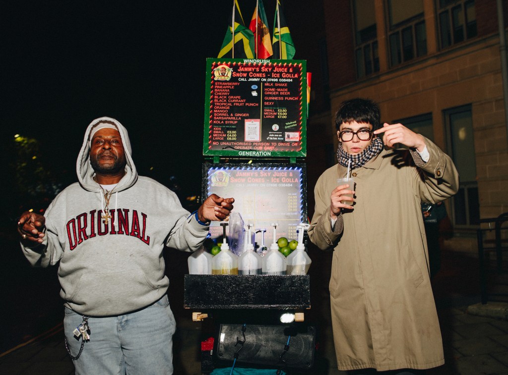 Two men next to a Jamaican drinks stall in Bristol