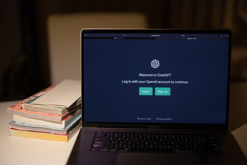 A laptop on a desk displaying a login screen for ChatGPT