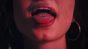 acid tab on a girl's tongue in an opwith hoop earrings