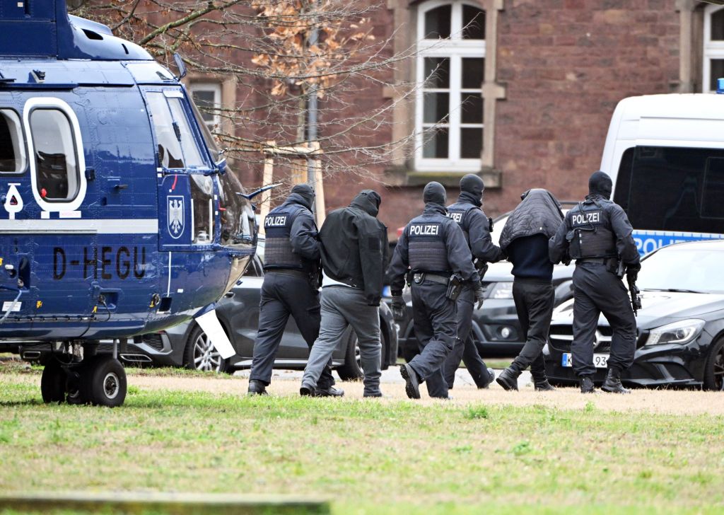 Two people are led from a helicopter to a car by police officers at a helipad. On 14.12.2023, the Federal Public Prosecutor's Office had four suspected members of the Islamist Hamas arrested in Berlin and Rotterdam in the Netherland.