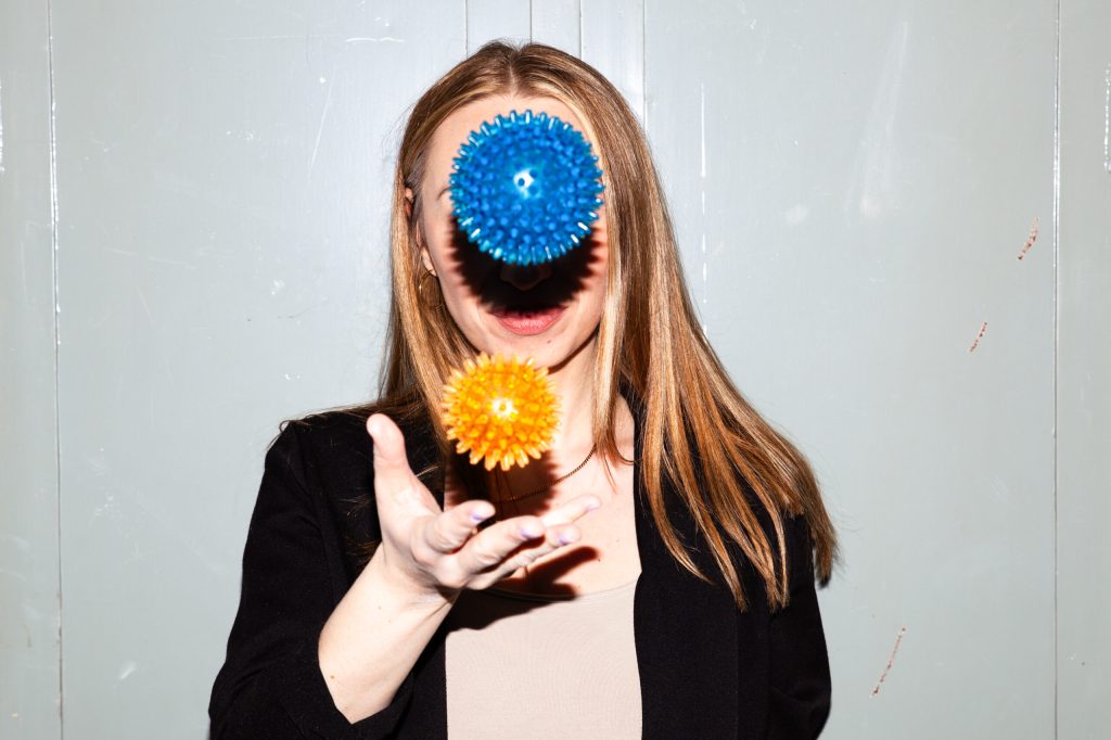 Mo, msninjaaa, Multiple sclerosis – woman with long blond hair, juggling two massage balls in the air in front of her face