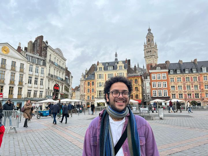 Young mixed race man with curly hair in town square