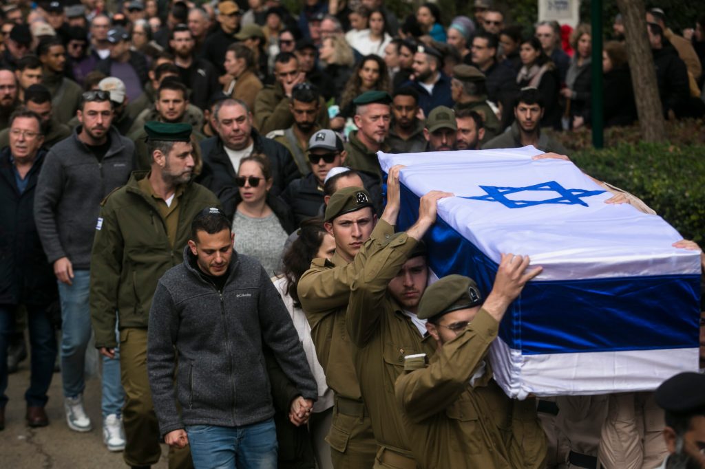 Family and friends mourn as they walk behind the coffin during the funeral of Sergeant major (res) Matan Lazar, killed in a battle in south Gaza on January 23, 2024 in Haifa, Israel.