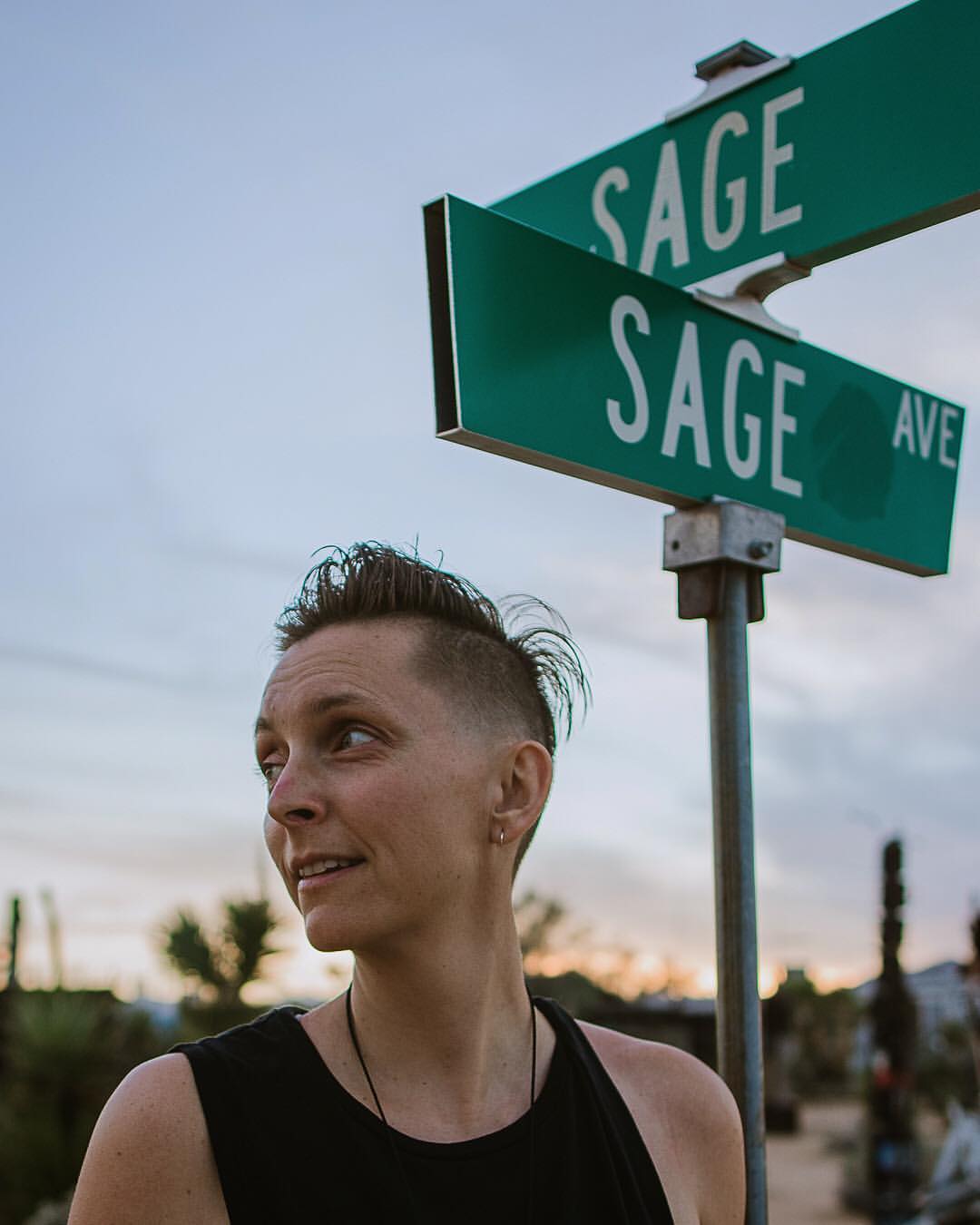 Portuguese digital nomad with shaved head posing against traffic sign