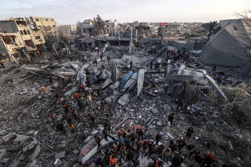 Palestinians stand amidst the rubble of a mosque and buildings which collapsed during Israeli bombardment around the town city of Rafah southern Gaza Strip on January 24, 2024, amid ongoing battles between Israel and the Palestinian militant group Hamas.