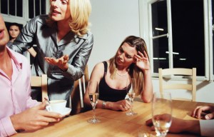 Three young people having seriousargume  at dinner party