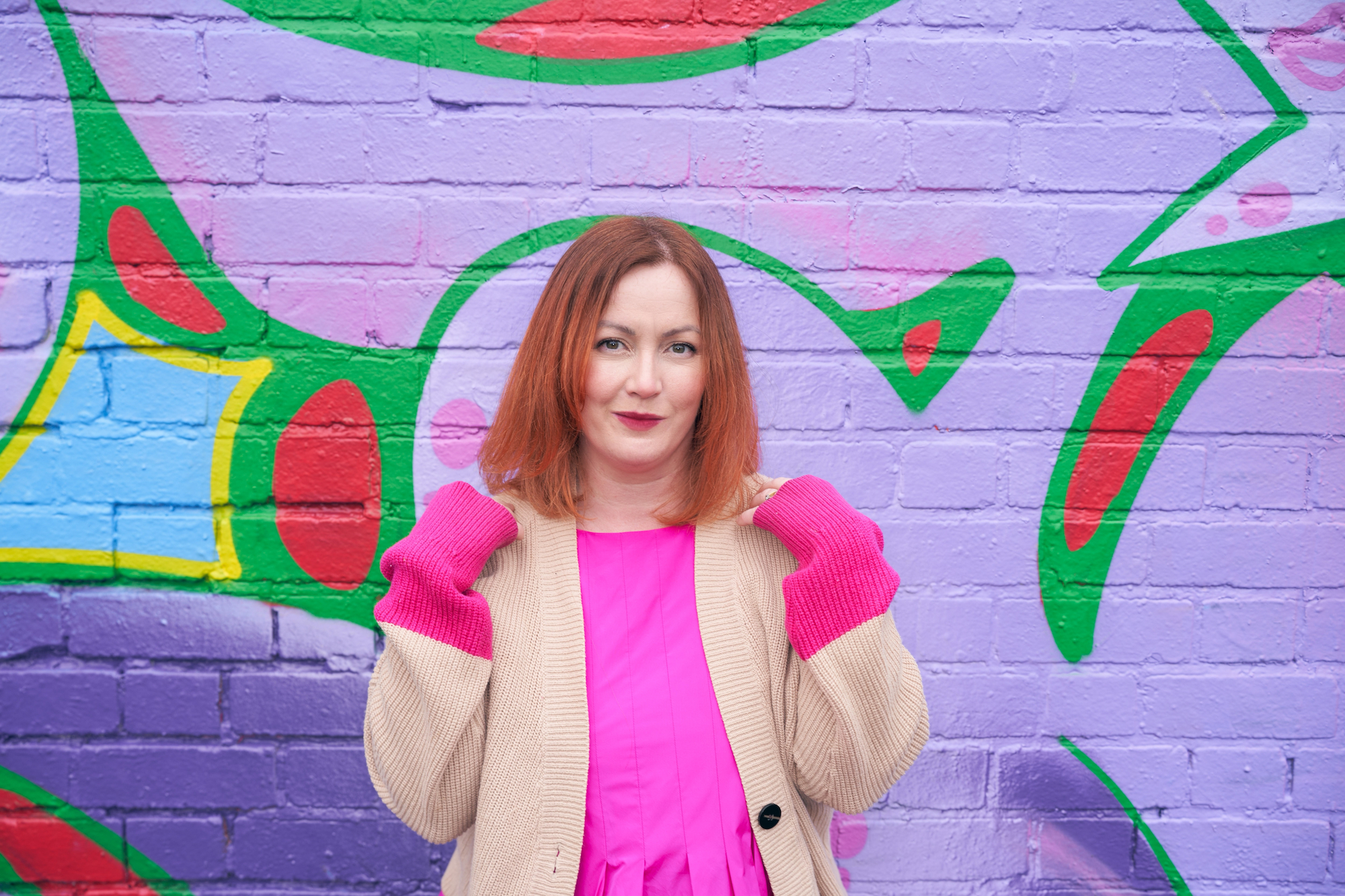 Author Kirsty Sedgman posing against graffiti backdrop