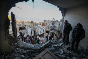 People inspect damaged home after Israeli air strike in Rafah