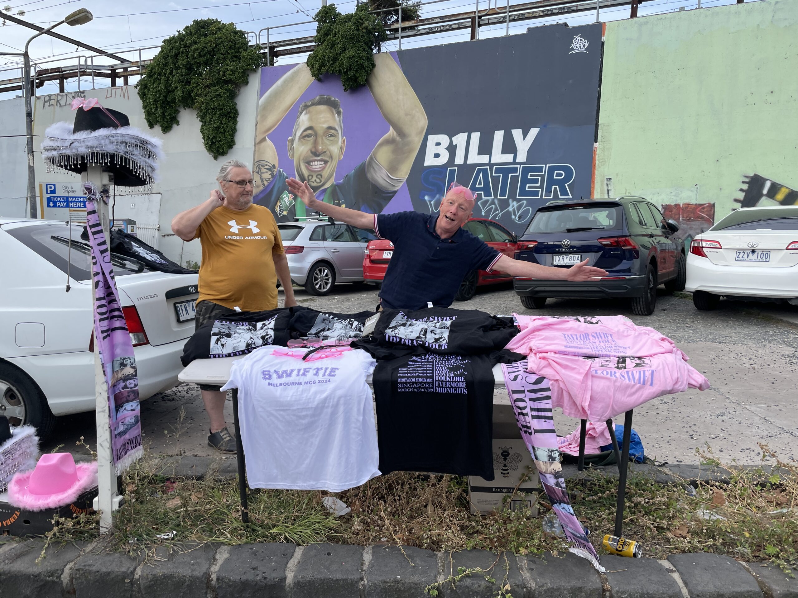 Two guys selling Taylor Swift merch