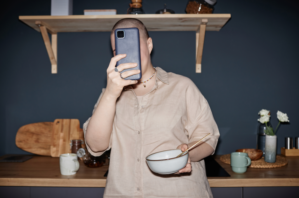 Image of person with phone over their face