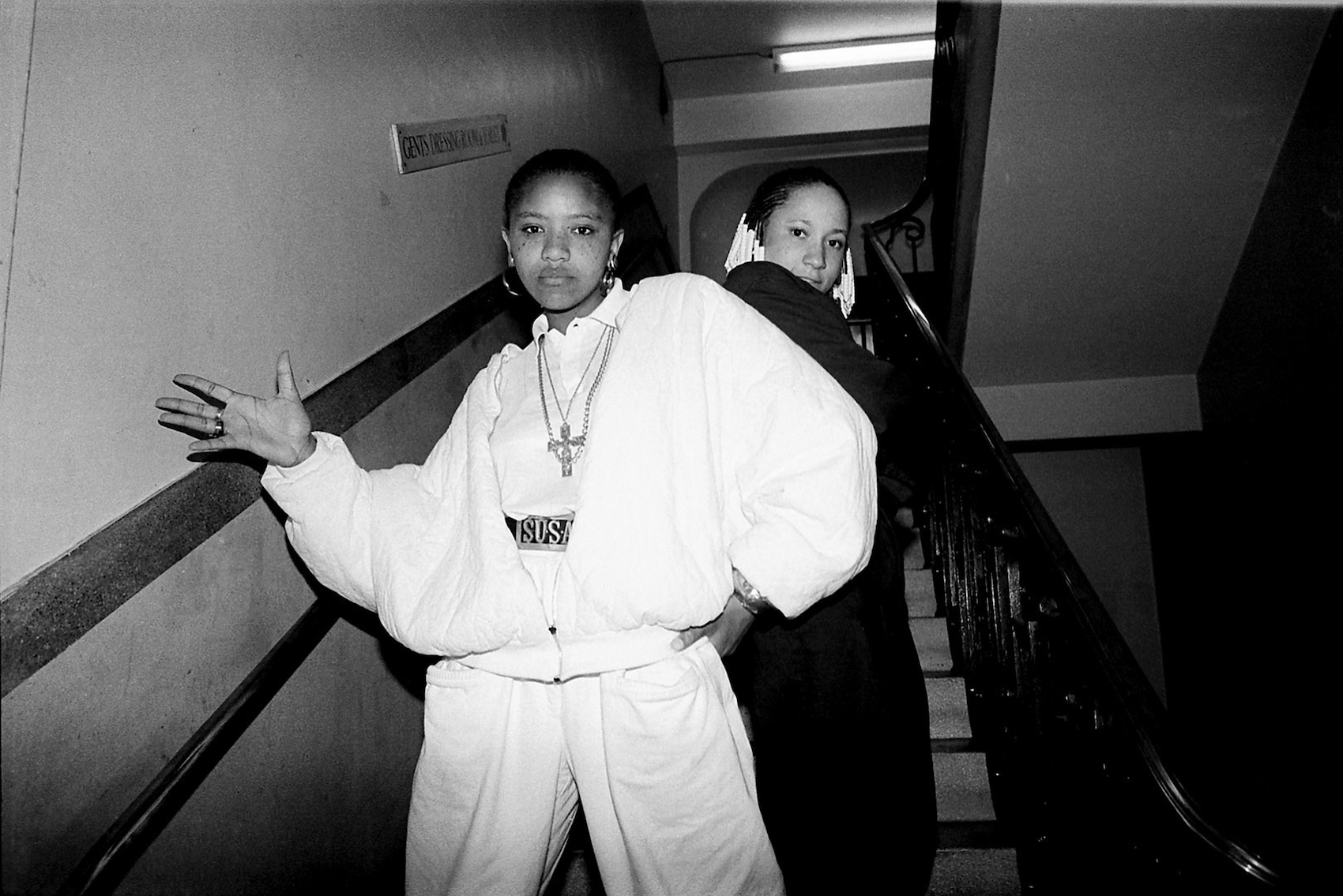 Two female artists pose for the camera on a staircase.