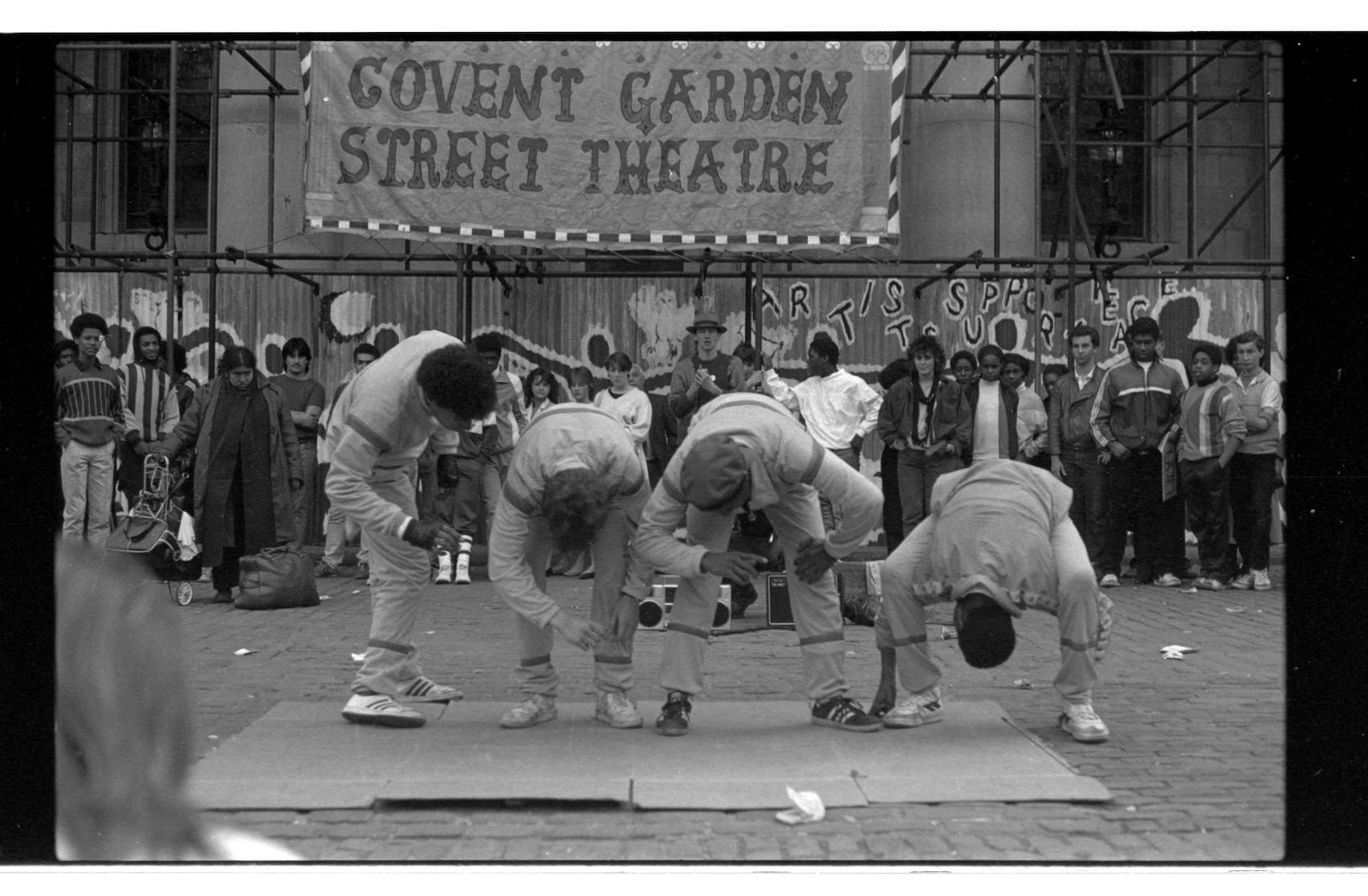 Four men breakdancing in the street.